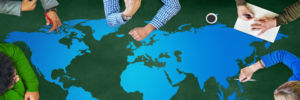 several people’s arms drawing on a large map of the world