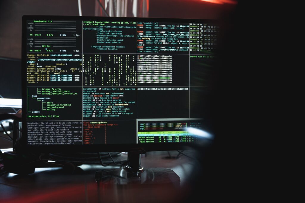 A computer monitor in a dimly lit room shows rows of code. The photo accompanies a blog about personality traits of successful cybersecurity professionals.