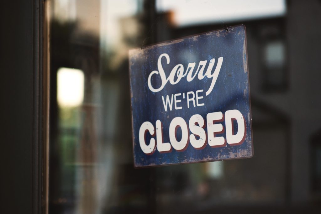 A sign hanging from a retailer’s window reads, “Sorry, we’re closed,” signifying the retail industry’s retail apocalypse.