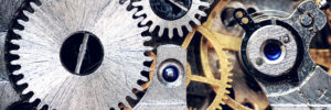 A close-up of a clock mechanism’s steel and metal gears signifies the many features that determine how personality tests work.
