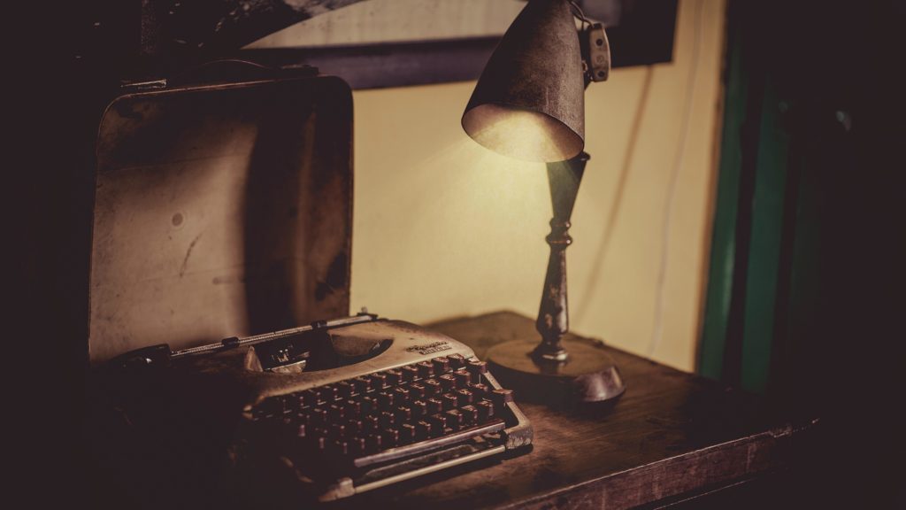 How necessary are cover letters in talent acquisition? They might be outdated — a sepia photograph of an antique typewriter illuminated by an old desk lamp illustrates the concept. 
