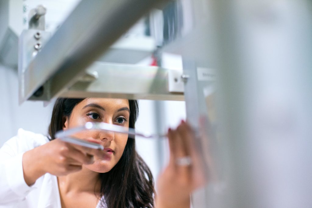 A close-up of an engineer as she works on manufacturing equipment. Because of the manufacturing talent shortage and skills gap, manufacturing leaders may struggle to find workers like this one who are skilled with Industry 4.0 technology. But personality assessments can help manufacturers thrive as they face these historic talent challenges. 