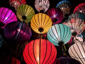 Multicolored lanterns glow against a dark background in a low-angle photograph, symbolizing the new year. The photo accompanies a blog post about the 2022 derailers of the year.