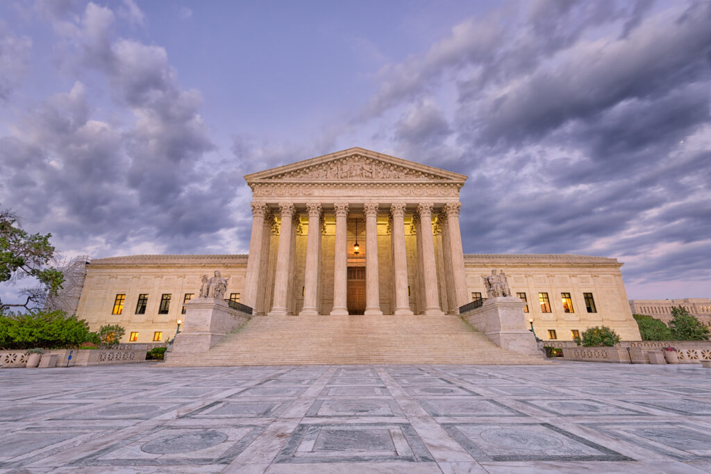 A low-angle photo of the US Supreme Court building against a cloudy backdrop accompanies a statement about Hogan's position on a recent ruling that invalidated race-conscious admissions programs at colleges and universities. Hogan is committed to equal opportunity, irrespective of changes in affirmative action legislation.