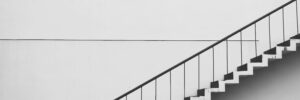 A monochrome image of a staircase, showcasing the contrasting shades of black and white, accompanies a blog post about adapting leadership development strategies across managerial levels.