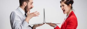 The young businessman and businesswoman with laptops on gray background