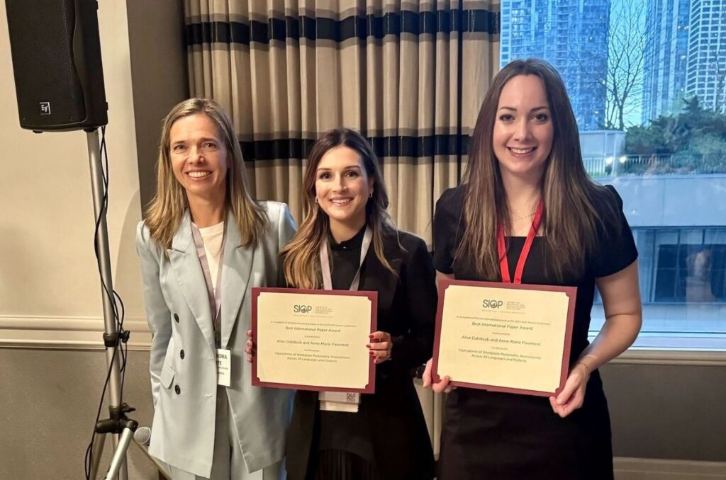 Anne-Marie Paiement, PhD, at center, and Alise Dabdoub, PhD, at right, pose with the 2024 SIOP Best International Paper Award. Standing at left is Aleksanda Luksyte, chair of the international affairs committee and associate professor at the University of Western Australia Business School.