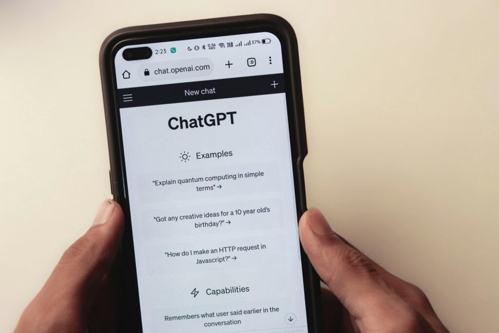 The webpage of ChatGPT, a prototype AI chatbot, is seen on the website of OpenAI, on a smartphone held against a beige background. The photo accompanies a blog post about getting assessment advice from ChatGPT.