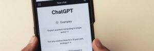 The webpage of ChatGPT, a prototype AI chatbot, is seen on the website of OpenAI, on a smartphone held against a beige background. The photo accompanies a blog post about getting assessment advice from ChatGPT.