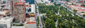 An aerial view of Mexico City showcases the contrast between Alameda Central park and the modern skyscrapers and historic buildings that surround it. The sharp division between urban development and green space represents how Mexican leaders’ personality trends help them navigate between tradition and ambition.