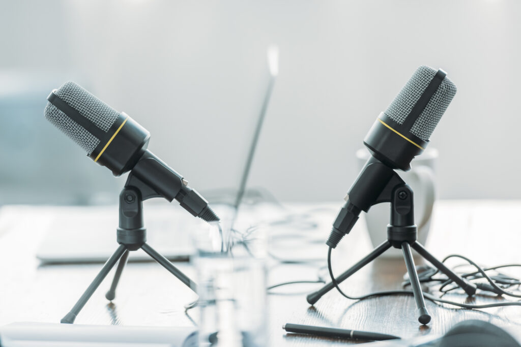 A podcast recording setup shows two microphones positioned across from each other in a bright, minimalist workspace. The image accompanies an article about The Science of Personality podcast listener questions.