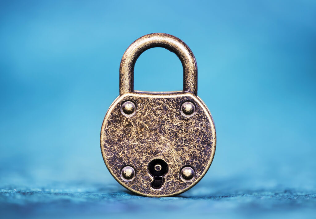 An aged, gold-toned metal padlock against a blue background. This image accompanies an article about five steps to a better high-potential program.