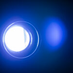 A flare of light with a halo glows blue against a dark background, signifying the Hogan derailer Bold, which regards overconfidence and arrogance.