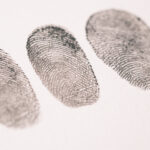 putting fingerprints on a paper close up ,