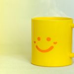 A yellow mug with a smiley face design signifies the outward agreement and passive aggression associated with Leisurely derailment. The image accompanies a blog post about working with passive-aggressive leaders.